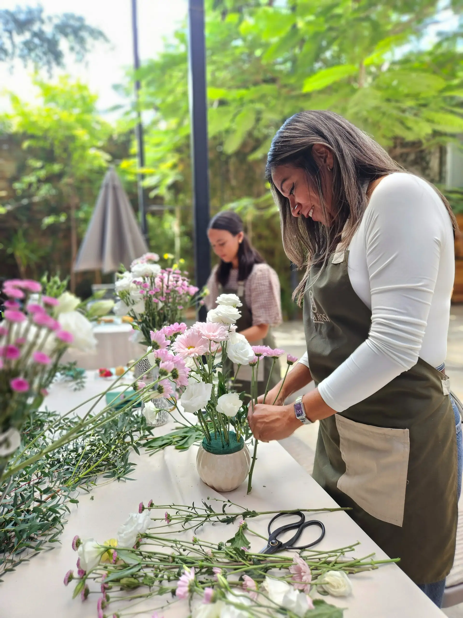 Participantes creando su arreglo en una Experiencia Floral